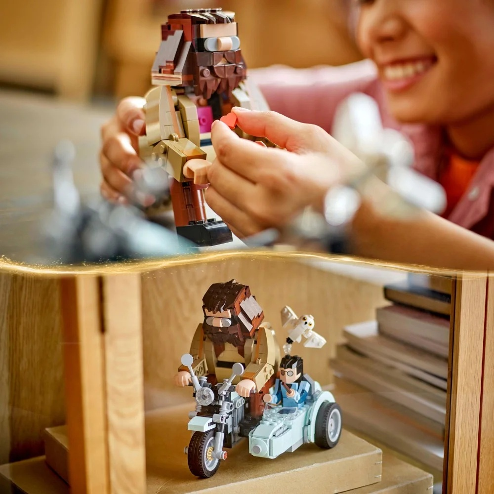 Osoba trzyma figurkę Lego Hagrida. Poniżej zestaw Lego przedstawia Hagrida na motocyklu z Harrym Potterem i Hedwigą.