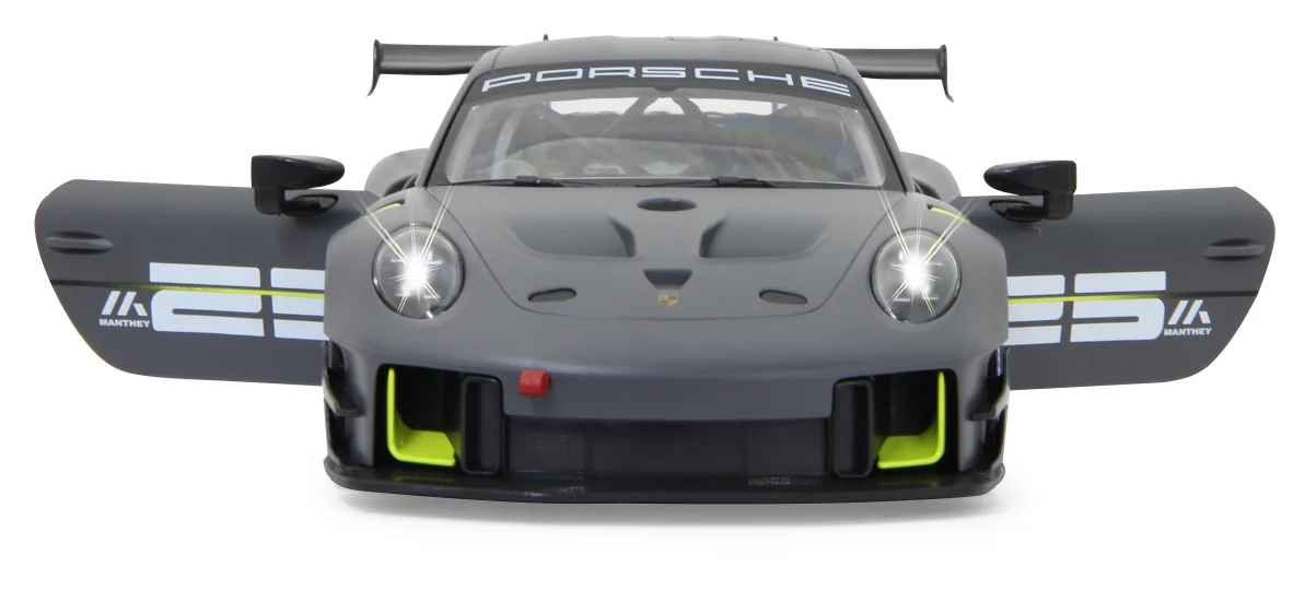 Szürke Porsche versenyautó nyitott ajtókkal, fényes fényszórókkal és hátsó szárnnyal. Az ajtókon Manthey logók találhatók.