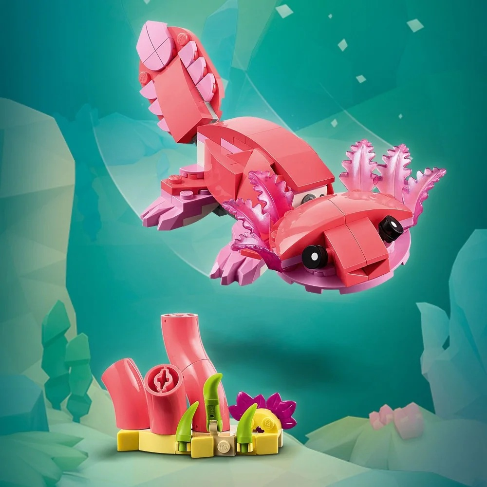 Klocki Lego axolotl pływają nad koralowcami. Axolotl jest różowy i fioletowy. Koralowce, żółta podstawa i zielone rośliny poniżej.