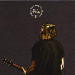 Ein Mann mit Dutt spielt Gitarre, mit dem Rücken zur Kamera, mit dem Text 'Fink II' und 'Wheels Turn Beneath My Feet'.