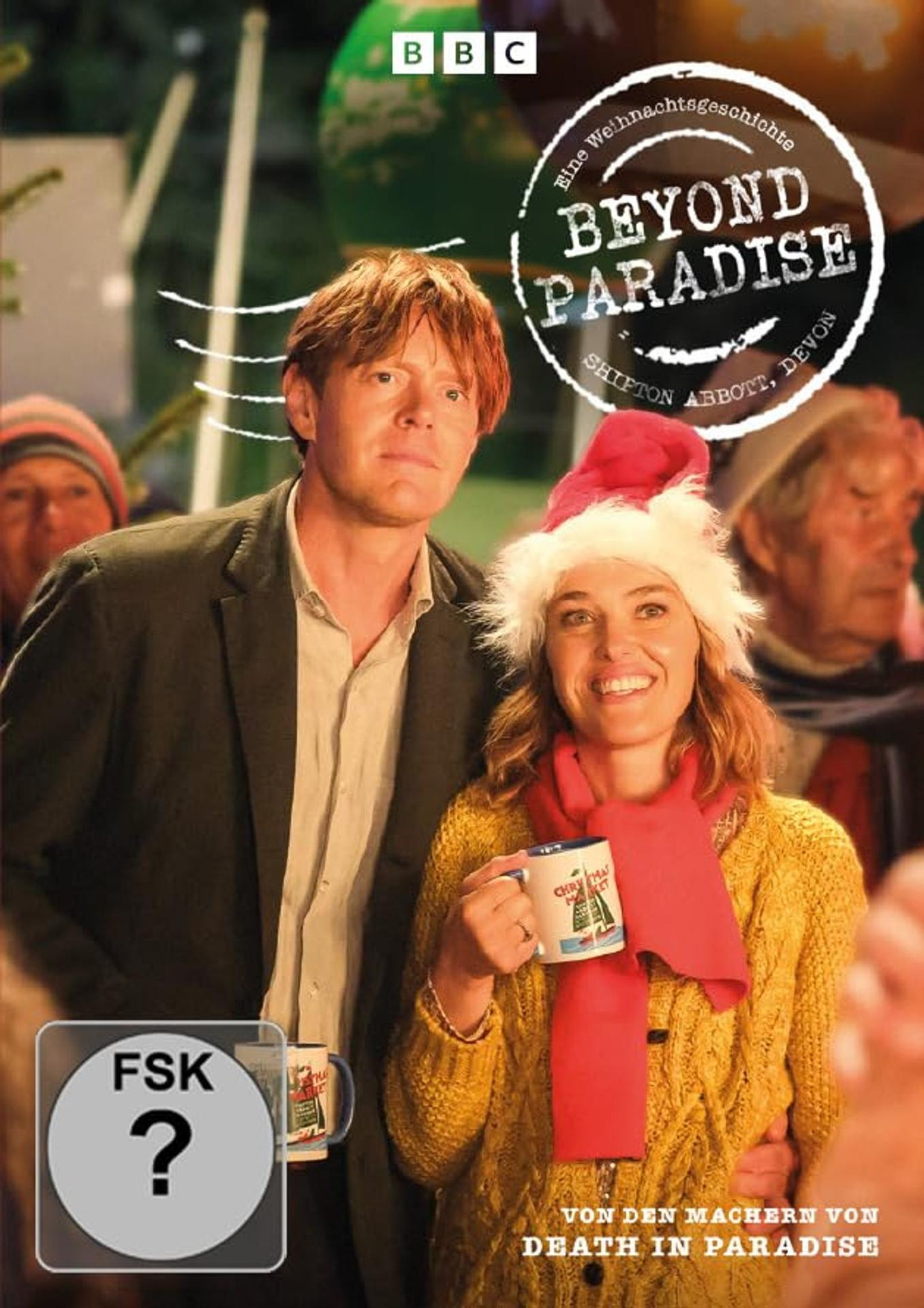 Ein Mann und eine Frau lächeln. Die Frau hält eine Tasse und trägt einen Weihnachtsmannhut und einen roten Schal. Der Titel lautet Beyond Paradise.