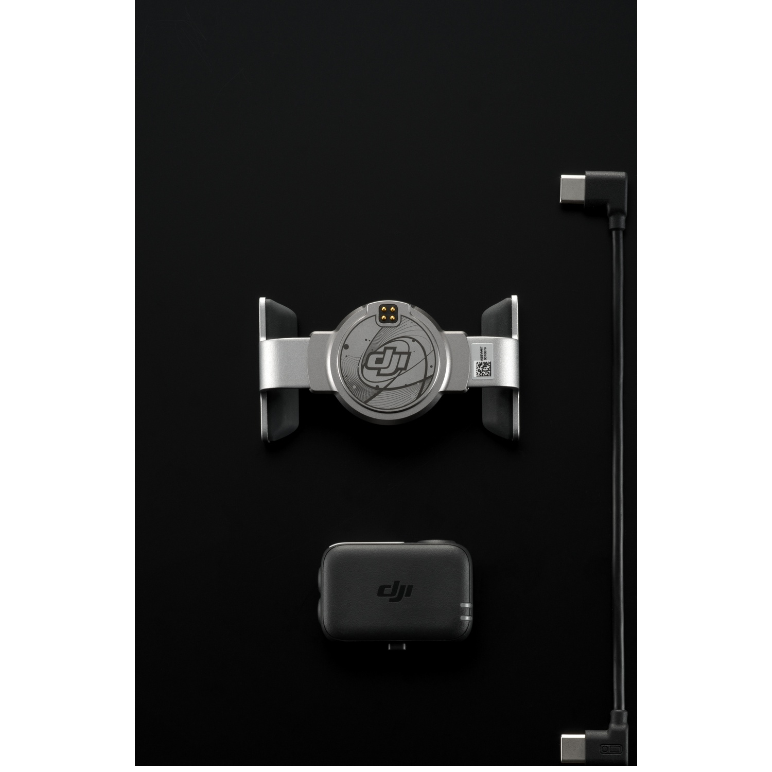 DJI product components on black. Includes a silver module, a black box, and a black USB cable.