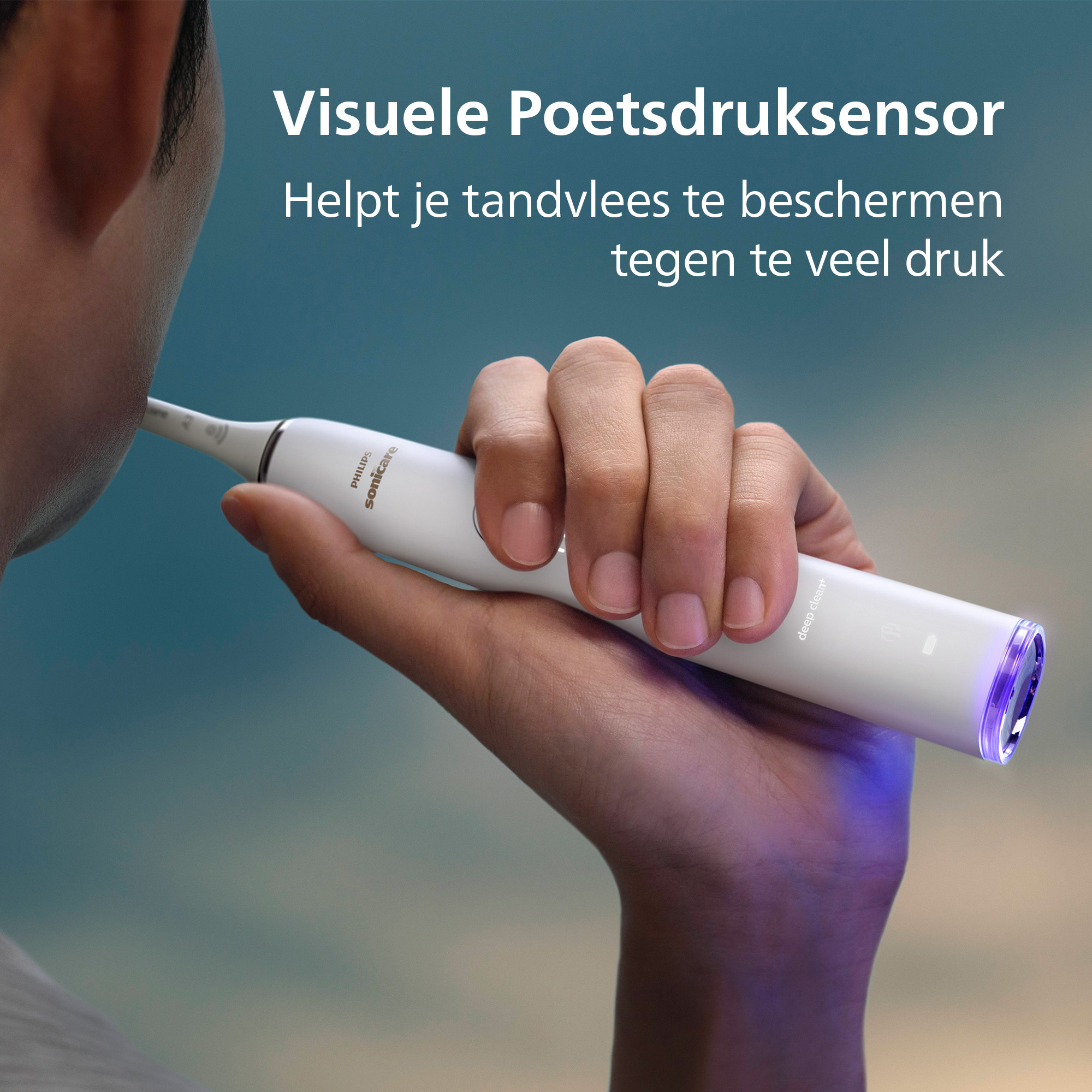 A person holding a white Philips Sonicare toothbrush. The toothbrush's end glows purple. Text in Dutch is visible.