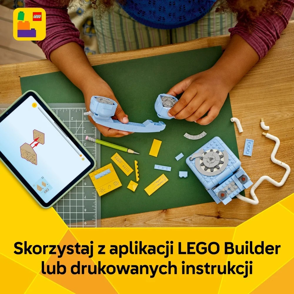 Dziecko składające zestaw LEGO z tabletem, niebieskie i żółte klocki na zielonej macie, z wydrukowanymi instrukcjami.