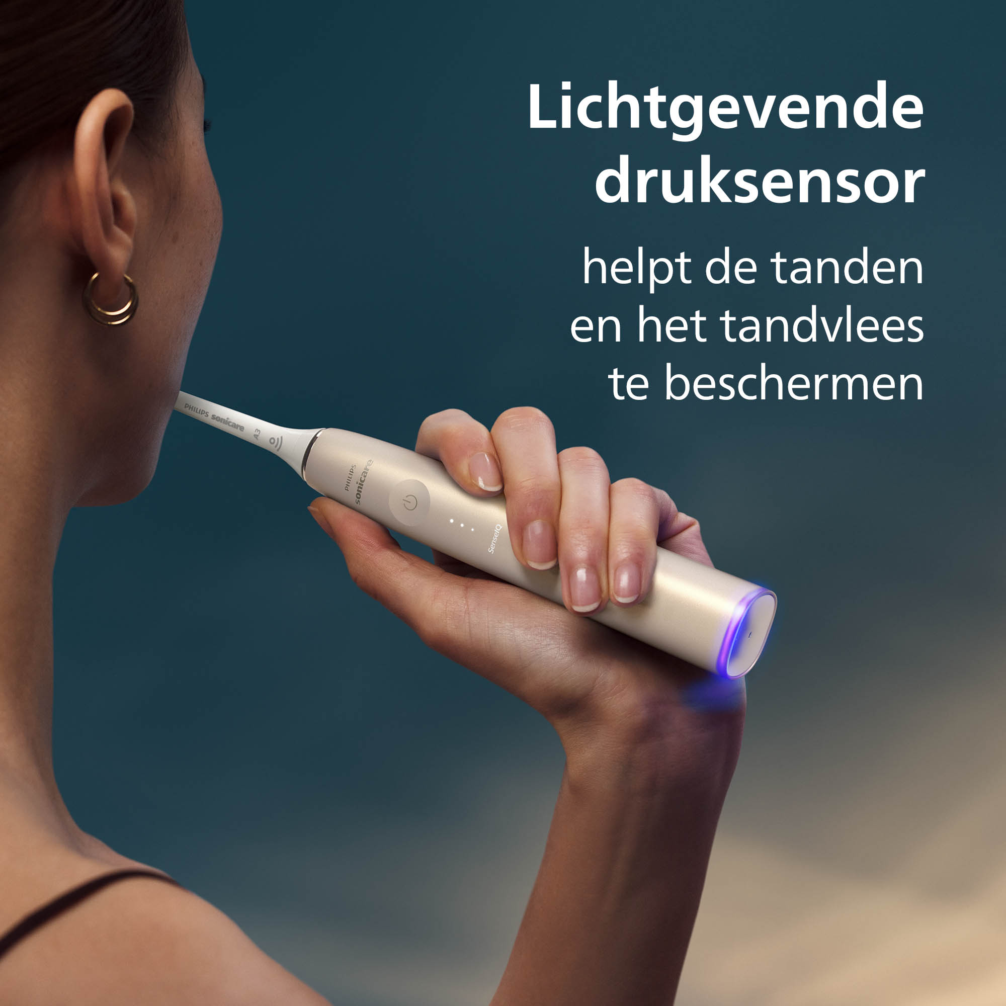 A woman using a Philips Sonicare toothbrush. The brush is held near her mouth. Text in Dutch is visible.