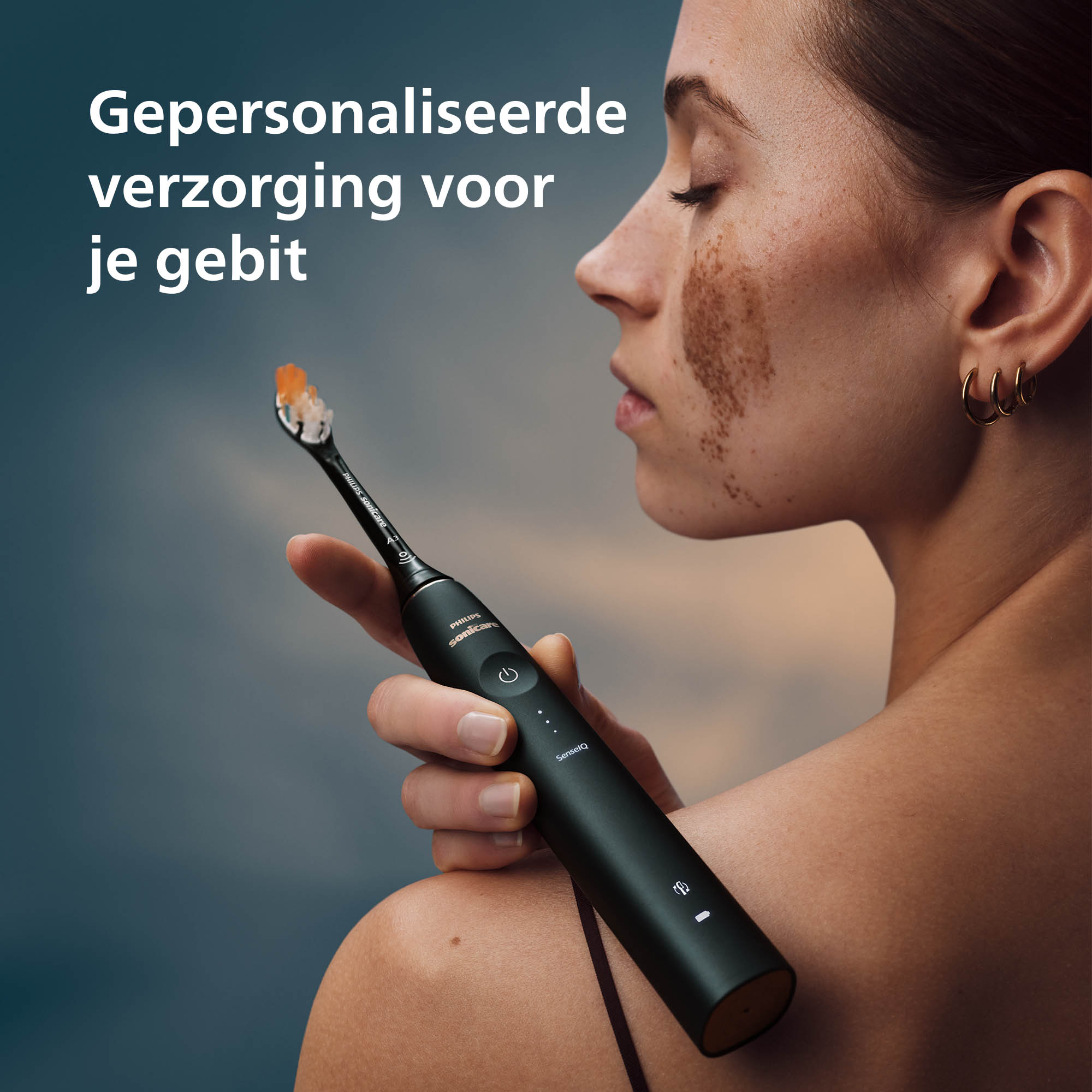 Vrouw met sproeten houdt een zwarte tandenborstel vast. Tekst: 'Gepersonaliseerde verzorging voor je gebit'.