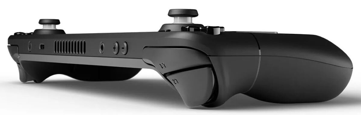 Czarny kontroler do gier przenośnych. Posiada przyciski, spusty i gałki. Jest na białym tle.