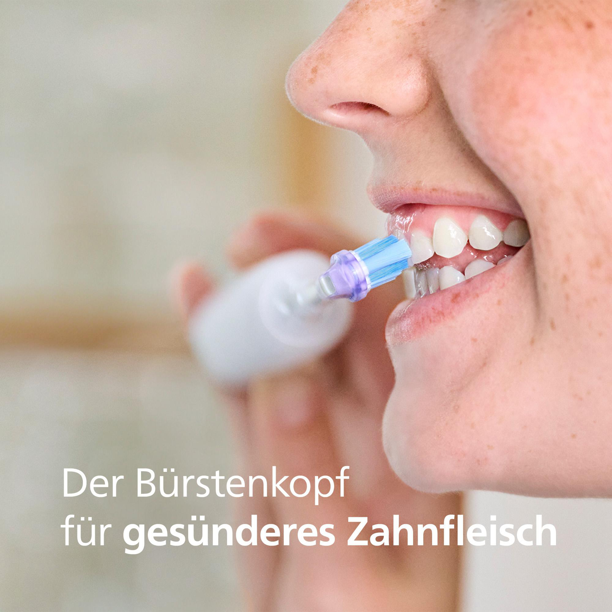 Nahaufnahme einer Person, die sich mit einer elektrischen Zahnbürste die Zähne putzt. Der Bürstenkopf ist blau und lila.