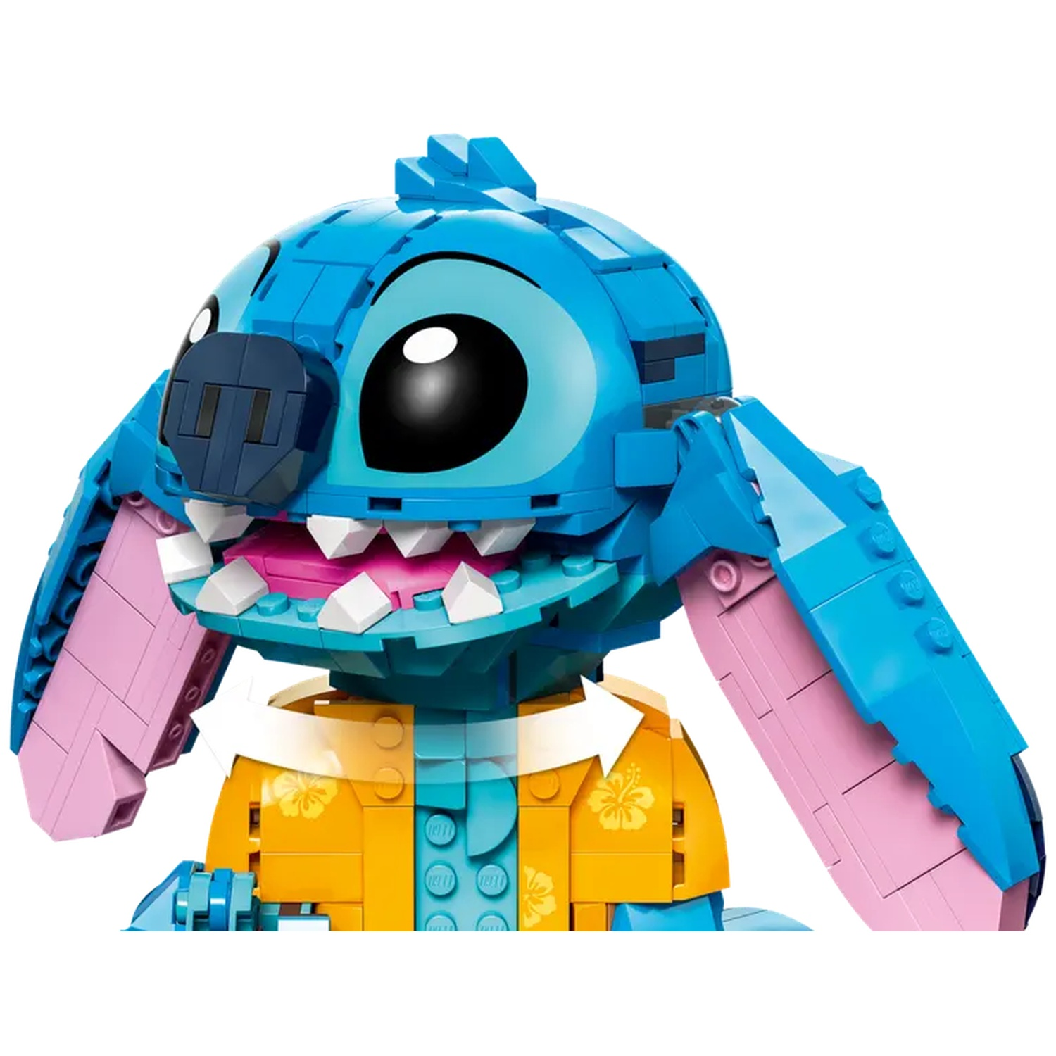 Een Lego Stitch-figuur, met een blauwe kop en oren, roze binnenoren en een geel overhemd. Het is een close-up.