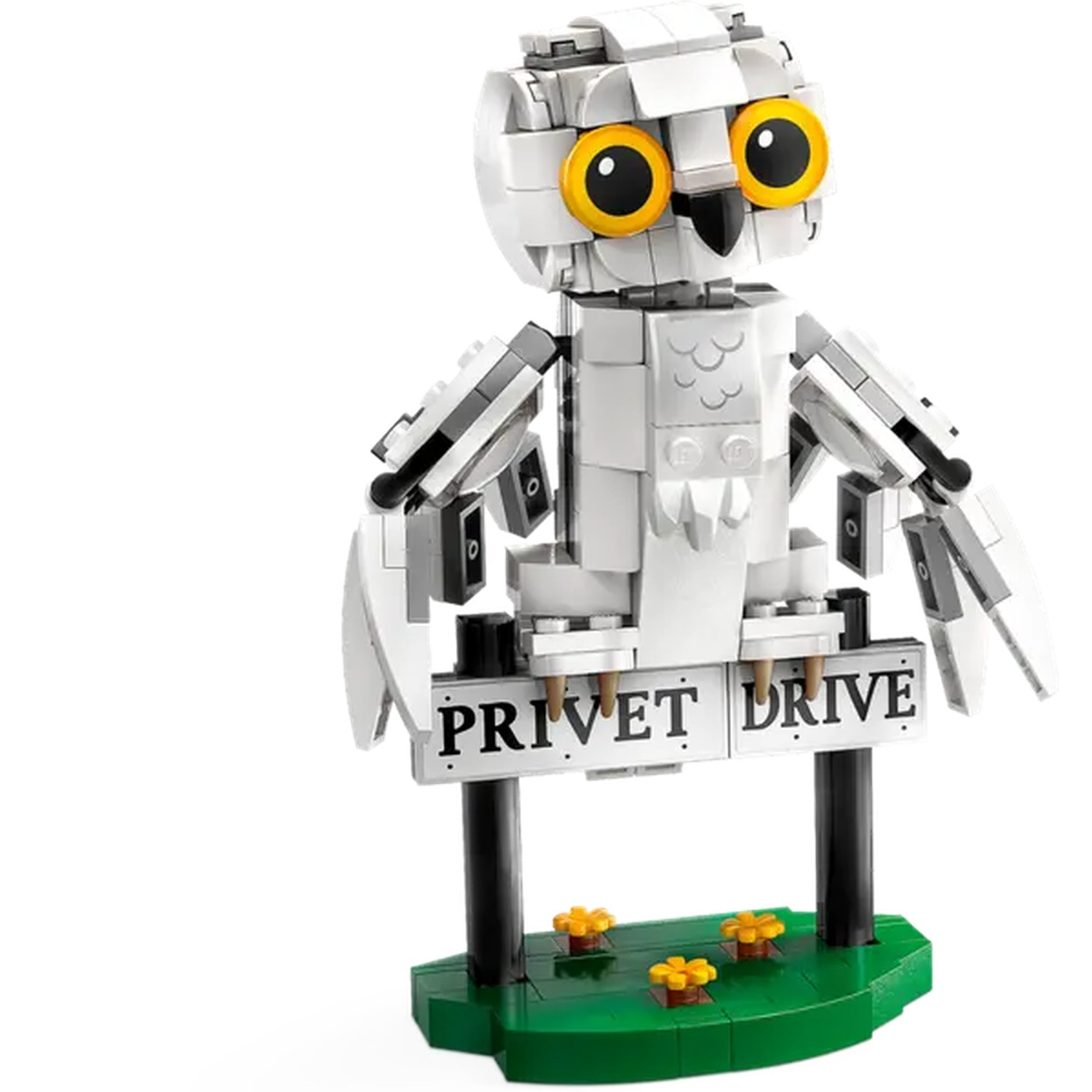 A Lego owl with large yellow eyes and a sign that reads 'Privet Drive'. The owl stands on a green base with flowers.