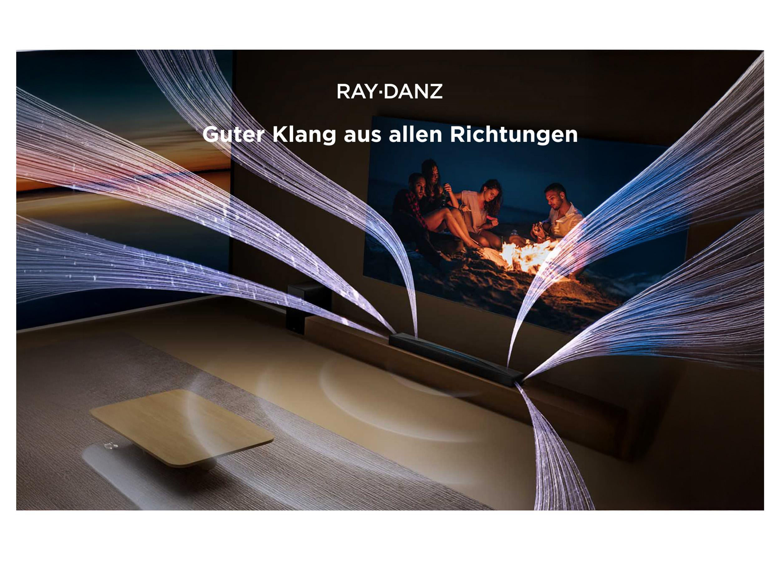 Wohnzimmer mit Soundbar, Fernseher mit Personen am Feuer und Lichtstrahlen. Text oben: RAY-DANZ.