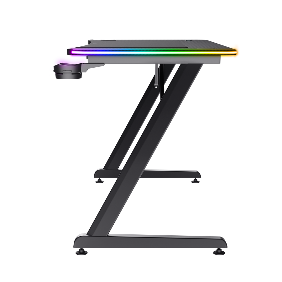 Escritorio gaming con patas negras en forma de Z. La parte superior tiene iluminación RGB. Un portavasos está en el lado izquierdo.