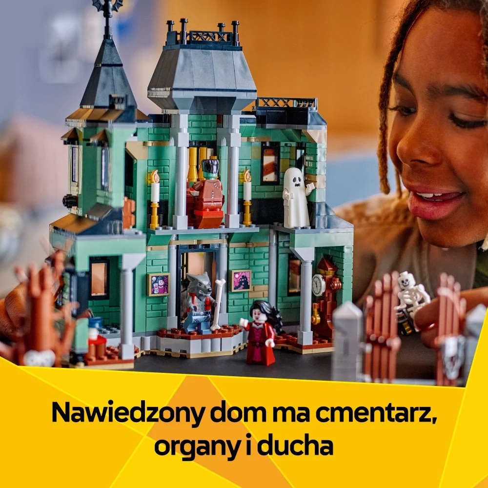 Dziecko uśmiecha się do nawiedzonego domu Lego. Są duchy, wilkołak, wampir i inne straszne postacie.