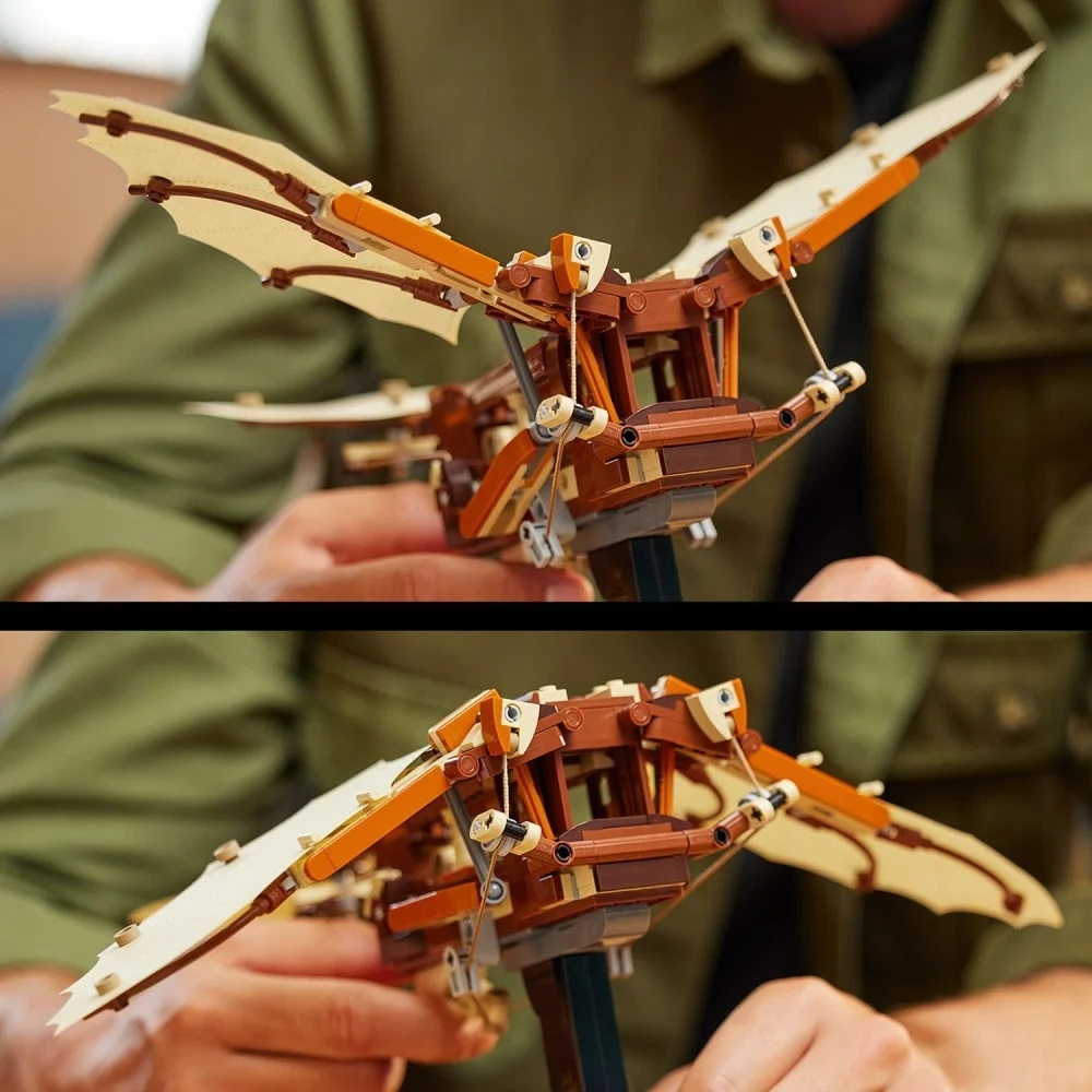 Osoba trzyma brązowo-beżowy model Lego latającej maszyny. Skrzydła są rozłożone, model jest szczegółowy, a tło rozmyte.