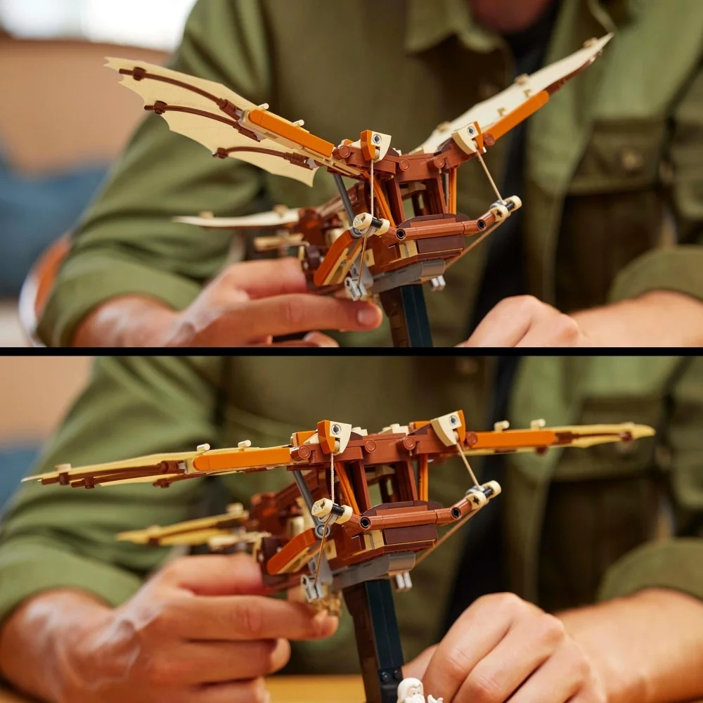 Osoba trzyma model Lego latającej maszyny. Ma brązowe i beżowe skrzydła oraz brązową ramę. Osoba ma na sobie zieloną koszulę.