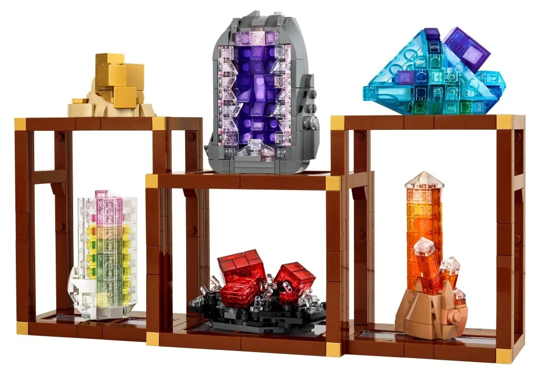 Ekspozycja Lego z kryształami i geodami. Brązowe półki zawierają różne kolorowe formacje Lego. Prezentowane są złote, fioletowe, czerwone i pomarańczowe kryształy.