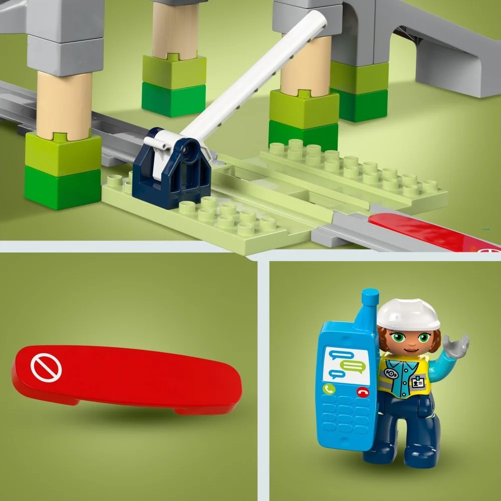 Zestaw zabawek kolejowych z torami, zaporą przejazdu, czerwonym znakiem stopu i figurką trzymającą niebieski telefon.