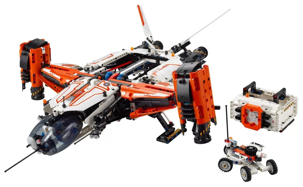 Model statku kosmicznego Lego Technic ze szczegółami w kolorze pomarańczowym i białym. Zawiera mały łazik i skrzynkę kontrolną. Wszystko na białym tle.