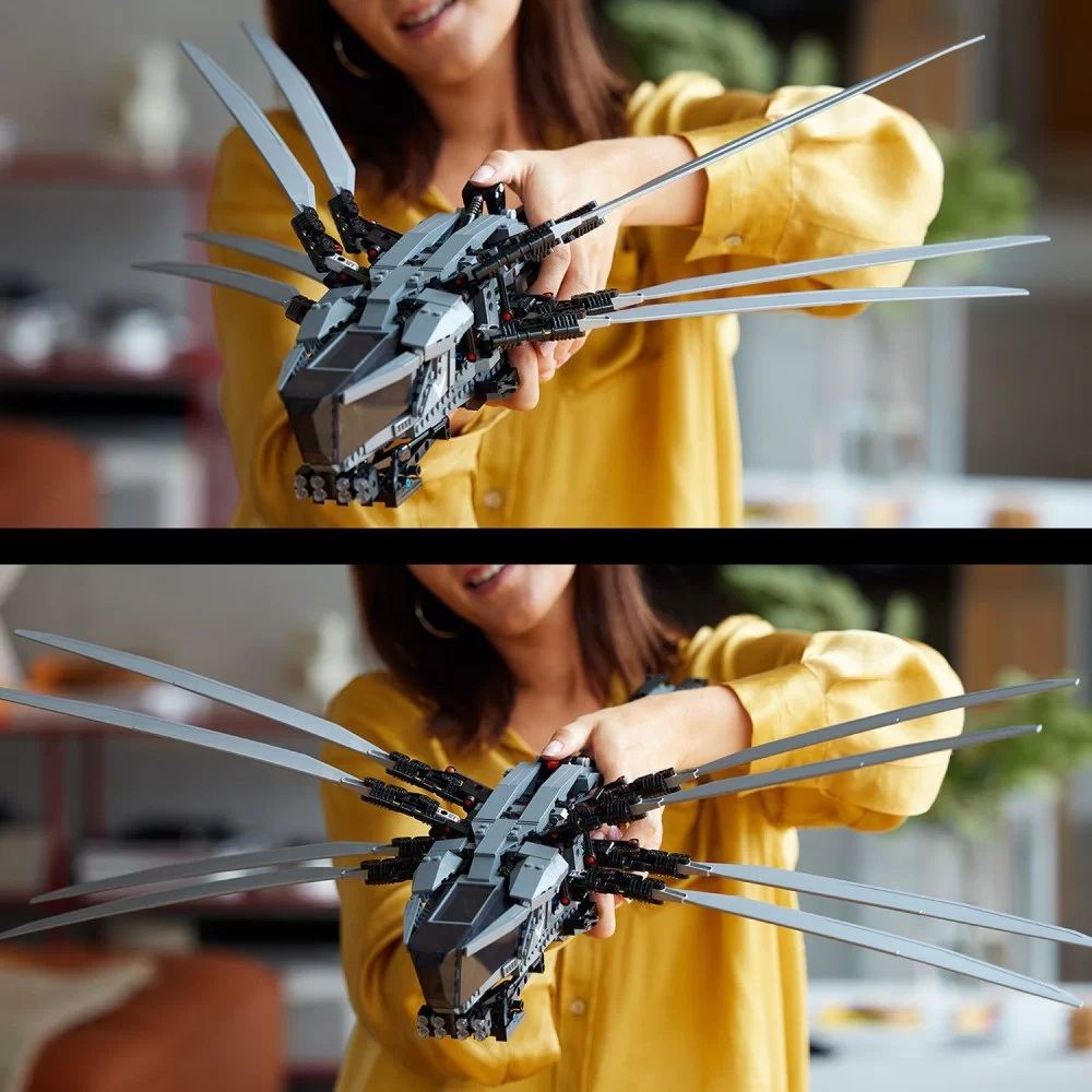 Kobieta trzyma szary model Lego z wysuniętymi ostrzami. Ma na sobie żółtą koszulę. Tło jest rozmyte.