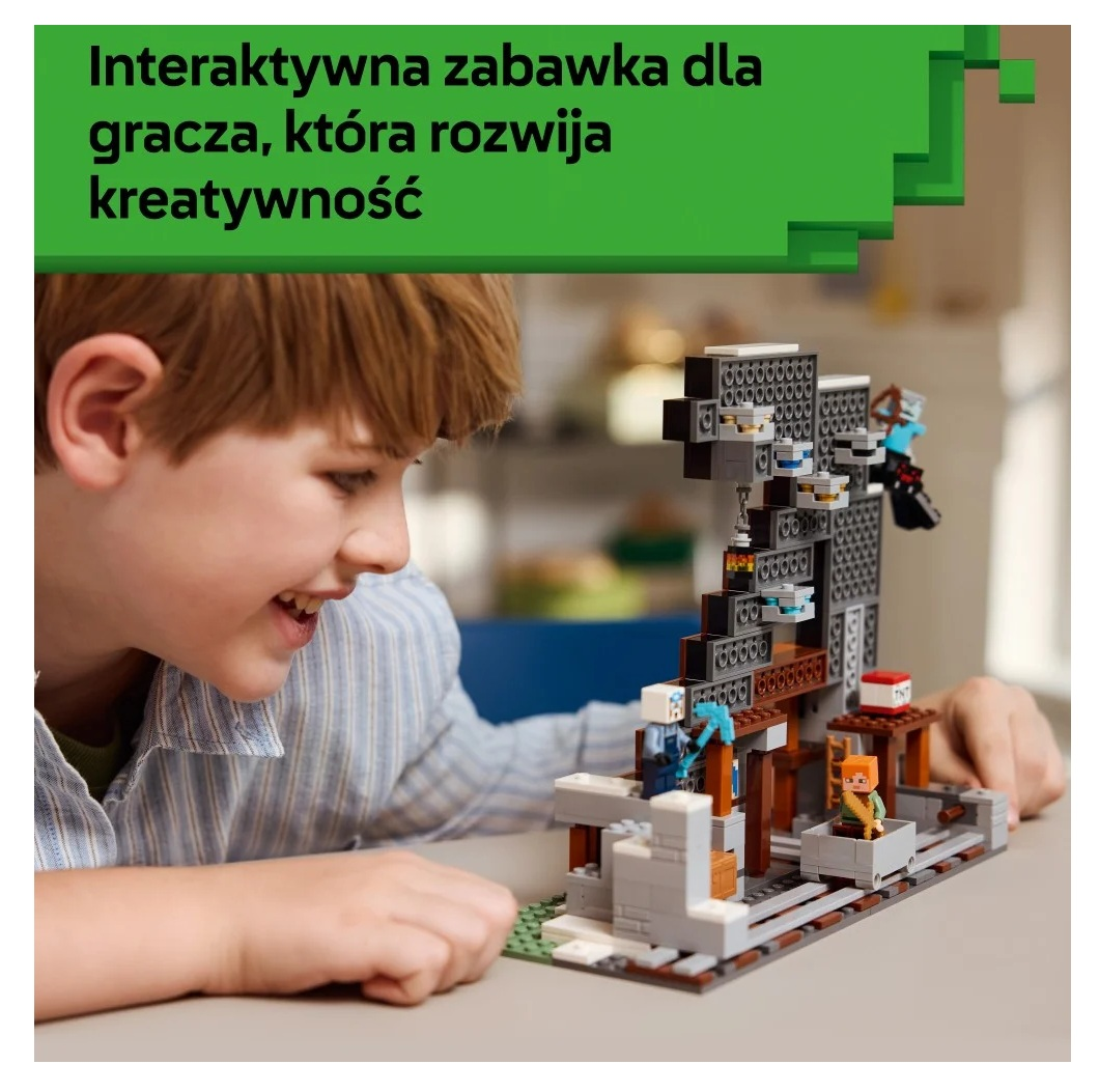 Chłopiec uśmiecha się do zestawu Lego Minecraft. Zestaw zawiera figurki i konstrukcje. Tło jest rozmyte.