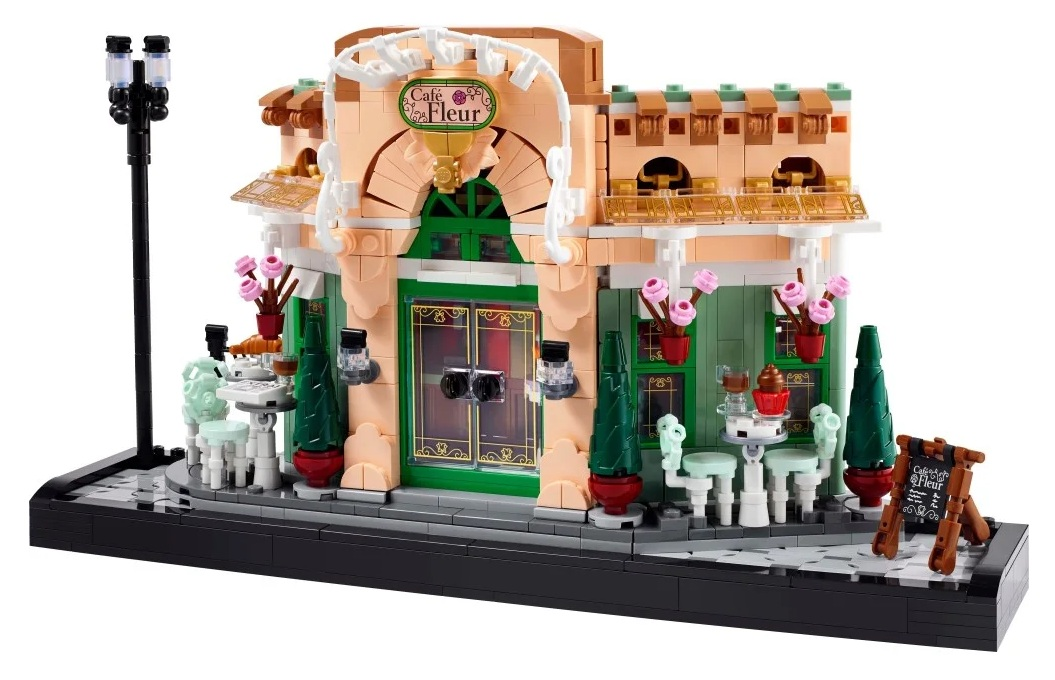 Kawiarnia Lego ze stolikami, krzesłami i kwiatami. Znak głosi 'Cafe Fleur'. Latarnia po lewej.