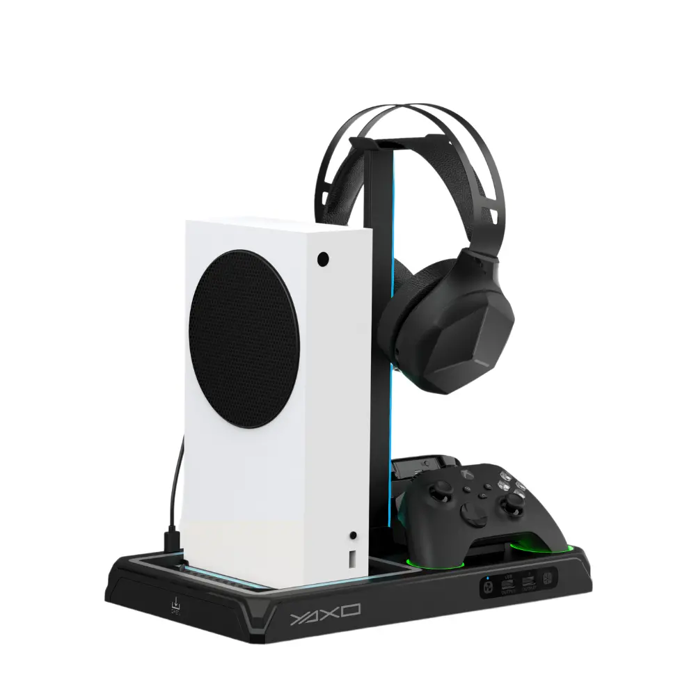 Biała konsola do gier, czarny zestaw słuchawkowy, kontroler i stojak znajdują się na czarnej podstawie. Zestaw słuchawkowy wisi na stojaku, kontroler spoczywa na podstawie.