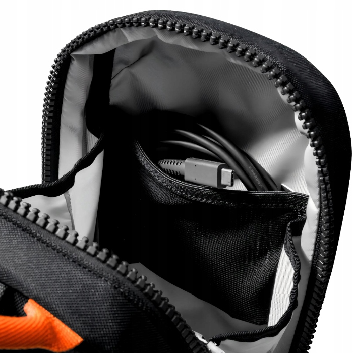 Otwarta czarna torba z zamkiem błyskawicznym. Wewnątrz widoczny czarny kabel z złączem USB-C. Wnętrze torby jest szare.