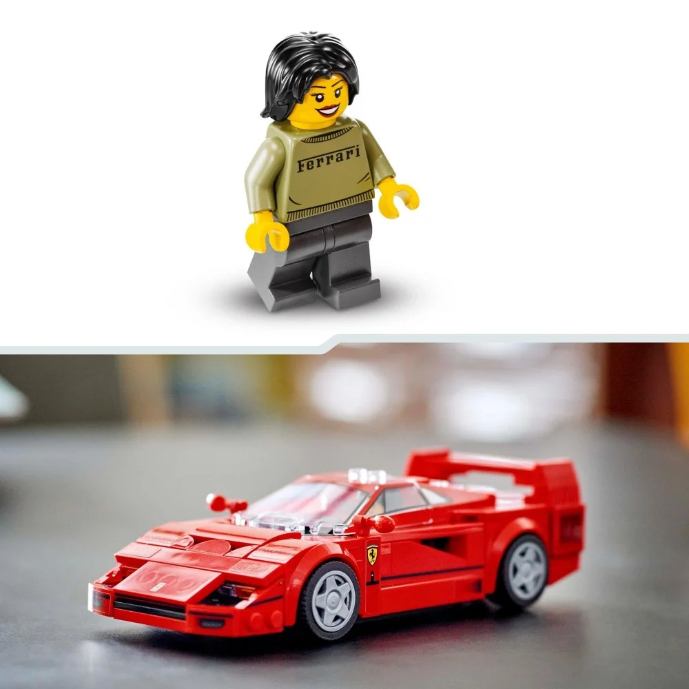 Figurka Lego w koszulce Ferrari stoi nad czerwonym samochodem Ferrari Lego na stole. Figurka ma czarne włosy.