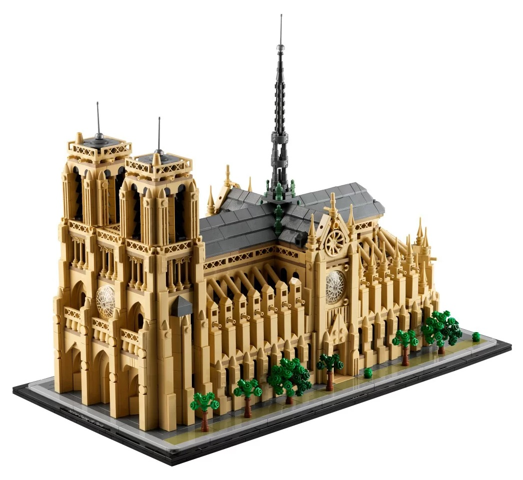 Model Lego katedry Notre Dame. Beżowe ściany, ciemnoszary dach, czarna iglica, małe zielone drzewa. Na czarnej podstawie.