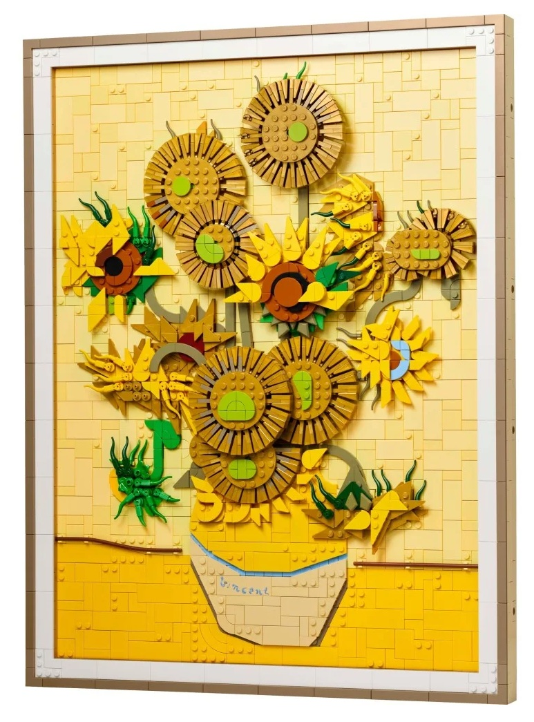 Lego rekreacja słoneczników Van Gogha. Żółte kwiaty w wazonie na żółtym tle z cegieł, oprawione w biało-brązową ramę.