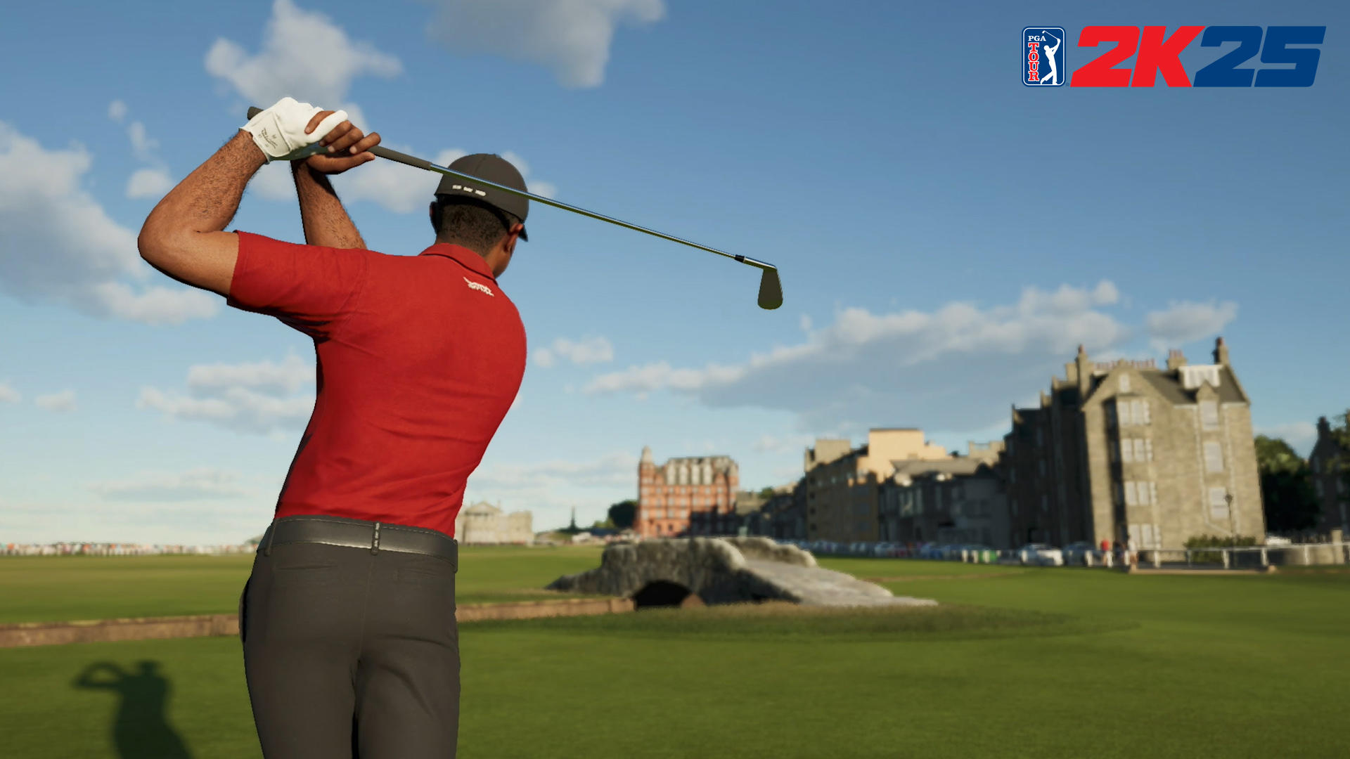 Golfer in rotem Hemd schwingt einen Golfschläger auf einem grünen Platz. Gebäude und blauer Himmel im Hintergrund. PGA 2K25 Logo.