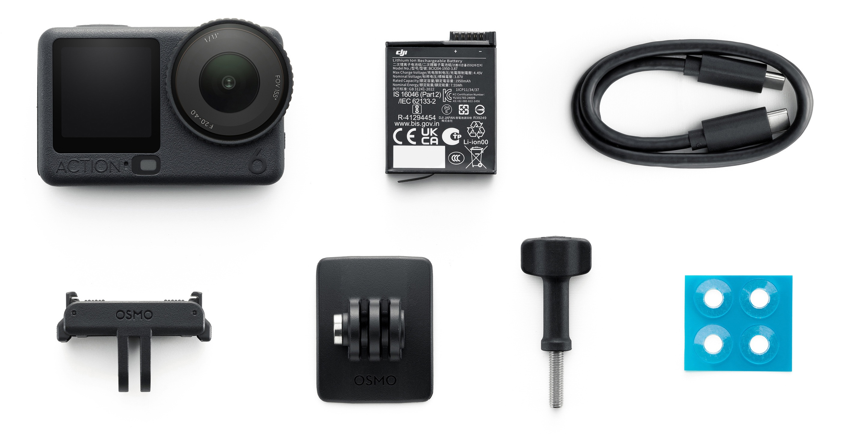Kamera DJI Action 2 z akcesoriami: bateria, kabel, uchwyty Osmo i osłony obiektywu na białej powierzchni.