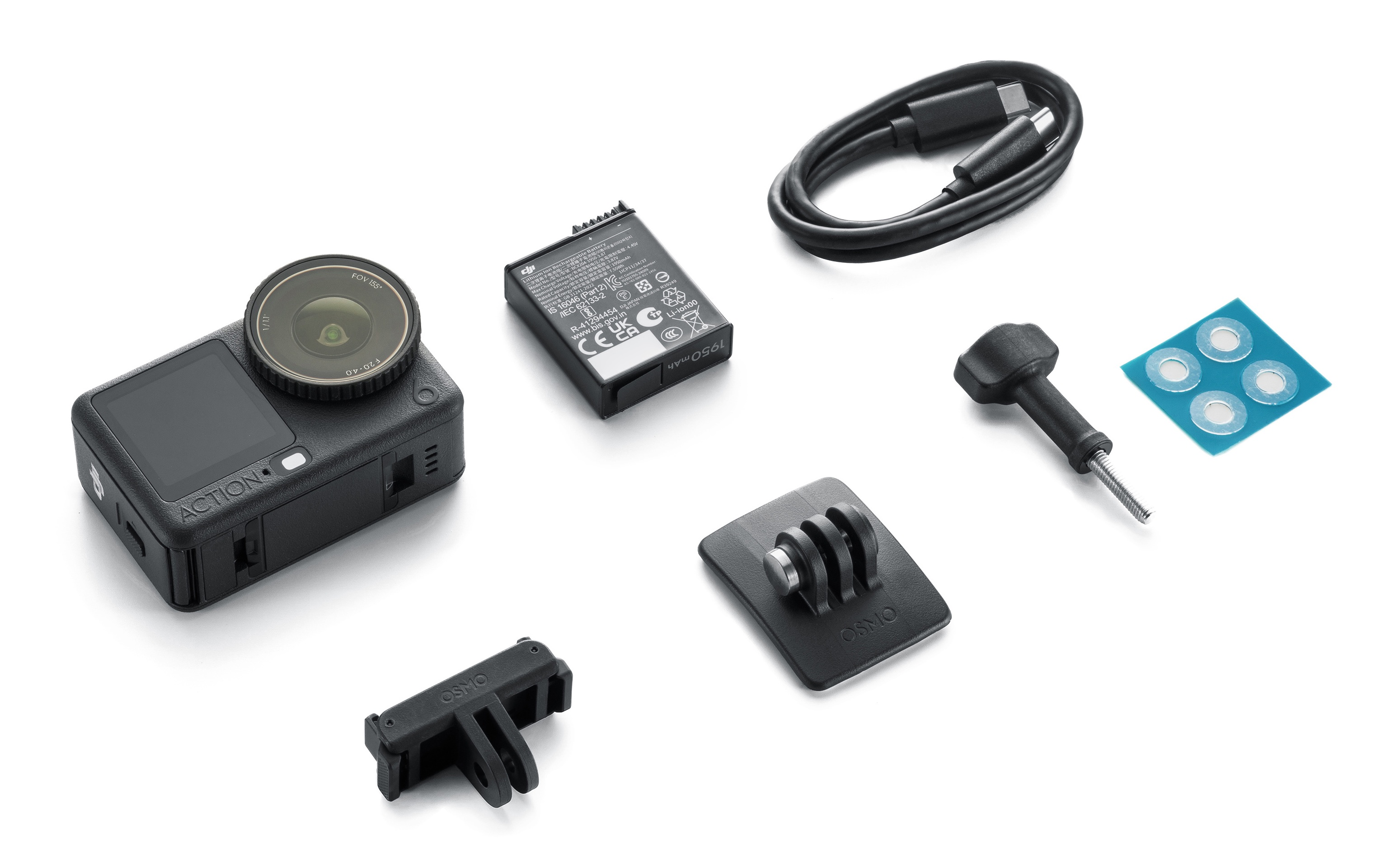 Czarna kamera sportowa z akcesoriami: bateria, kabel, uchwyty i mała niebieska naklejka z białymi naklejkami.