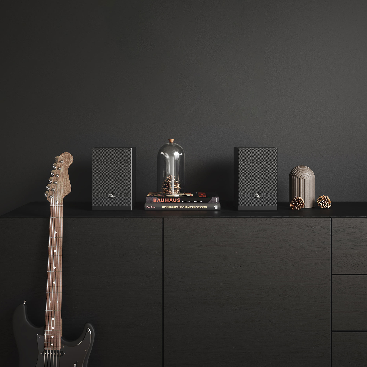 Een zwarte gitaar leunt tegen een zwarte kast. Luidsprekers, boeken, een glazen koepel en decoratie staan erop.