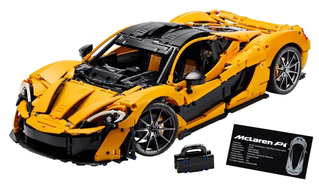 Model Lego McLaren P1. Jest żółty i czarny. Samochód ma czarne koła. Obok znajduje się czarne pudełko i karta.