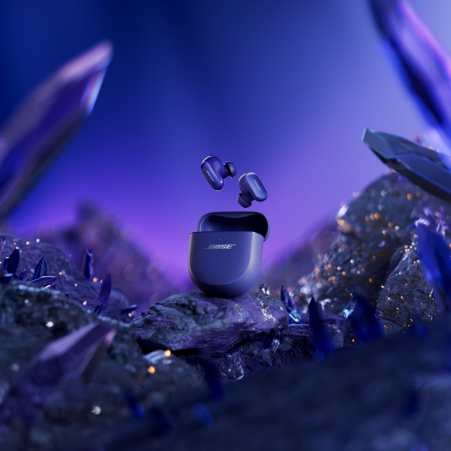 Auricolari Bose blu in una custodia di ricarica, con due auricolari fluttuanti sopra. Lo sfondo include cristalli e una sfumatura viola.