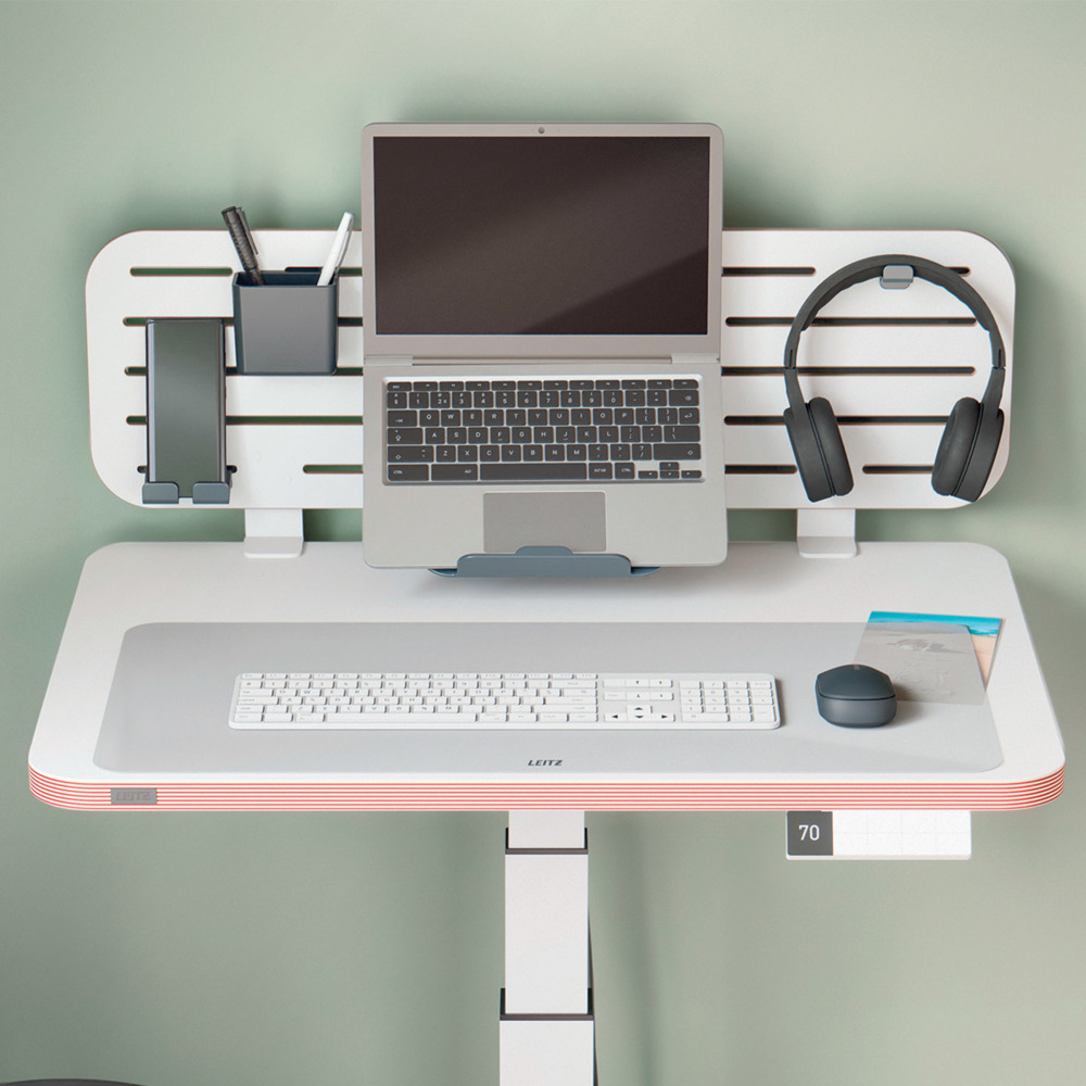 Modern íróasztal laptop-pal, billentyűzettel, fejhallgatóval és kiegészítőkkel. Az asztal fehér, piros csíkokkal.