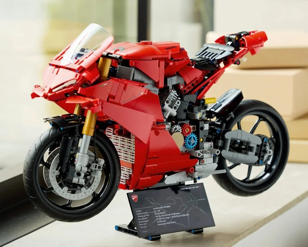 Czerwony model LEGO Ducati Panigale V4 lewituje. Posiada czarne koła, przezroczystą przednią szybę i czarny panel informacyjny.