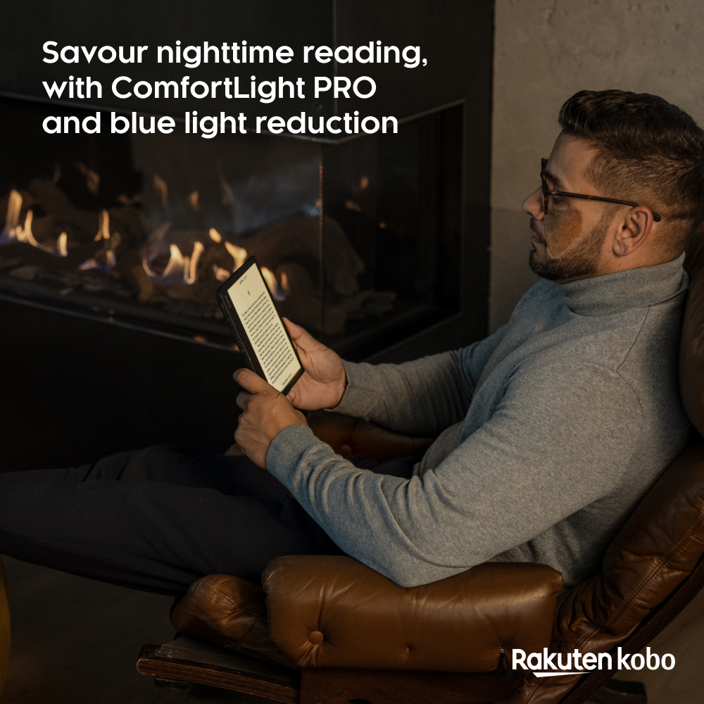 Férfi e-olvasót olvas a kandalló mellett, szemüveget és szürke pulóvert visel, bőr karosszékben ül. Rakuten Kobo logó.