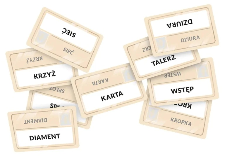 Karty rozrzucone na białej powierzchni. Karty zawierają polskie słowa, np. 'DIAMENT', 'KRZYŻ', 'KARTA'.