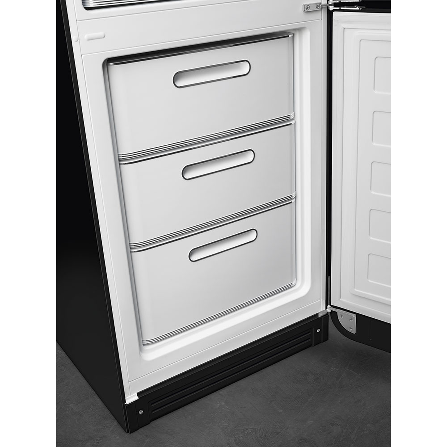 Open refrigerator showing three drawers. Drawers are white with silver handles. The door is also open.