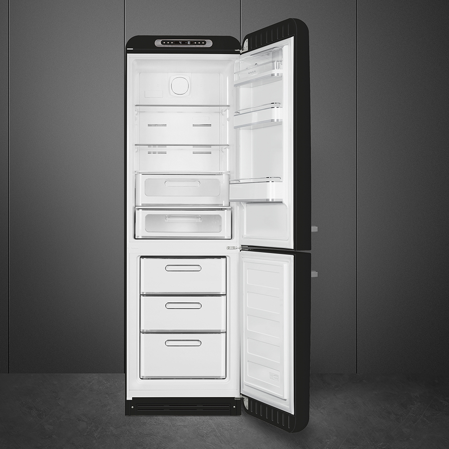 Open black refrigerator. Interior visible with shelves, drawers, and white compartments. Dark gray background and floor. 