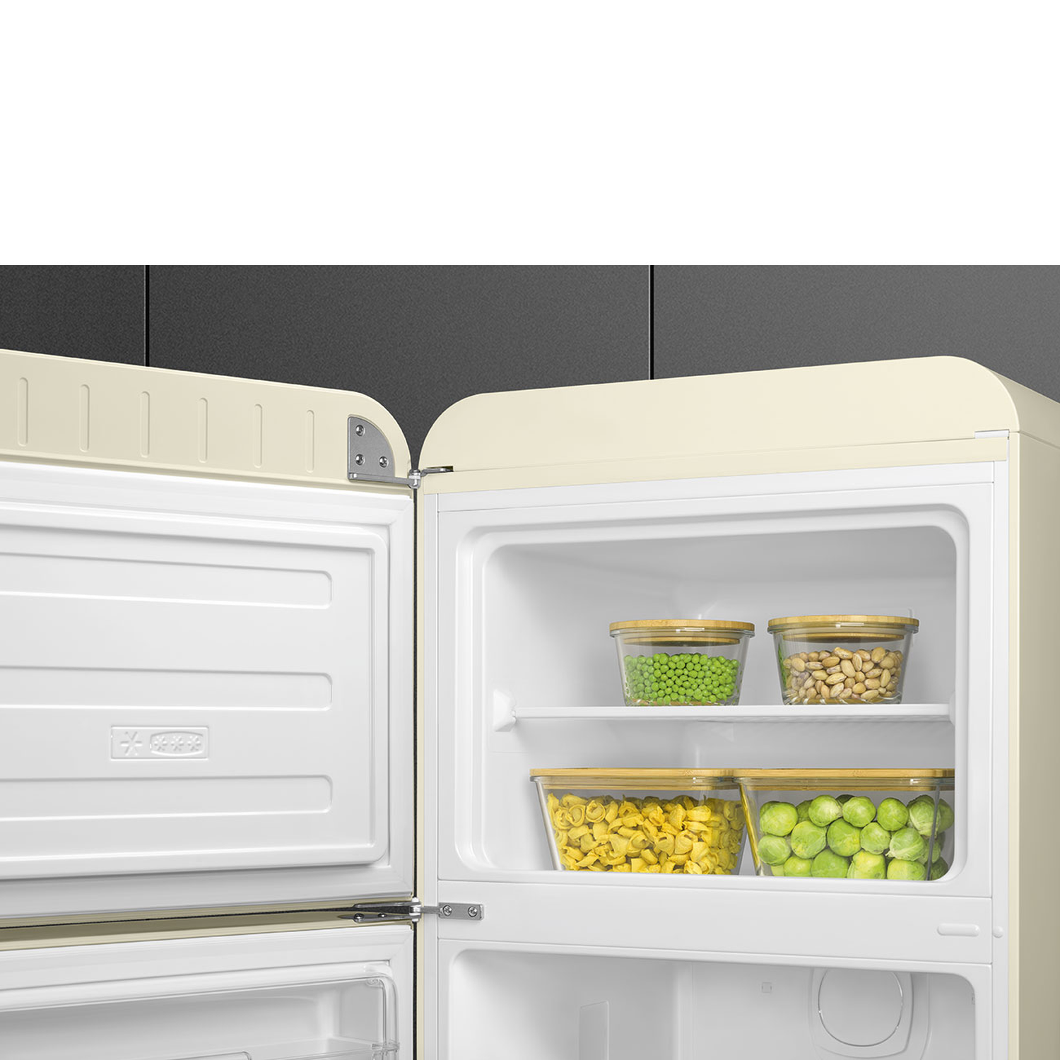 Open cream-colored refrigerator with vegetables in containers. Peas, beans, tortellini, and Brussels sprouts are visible.