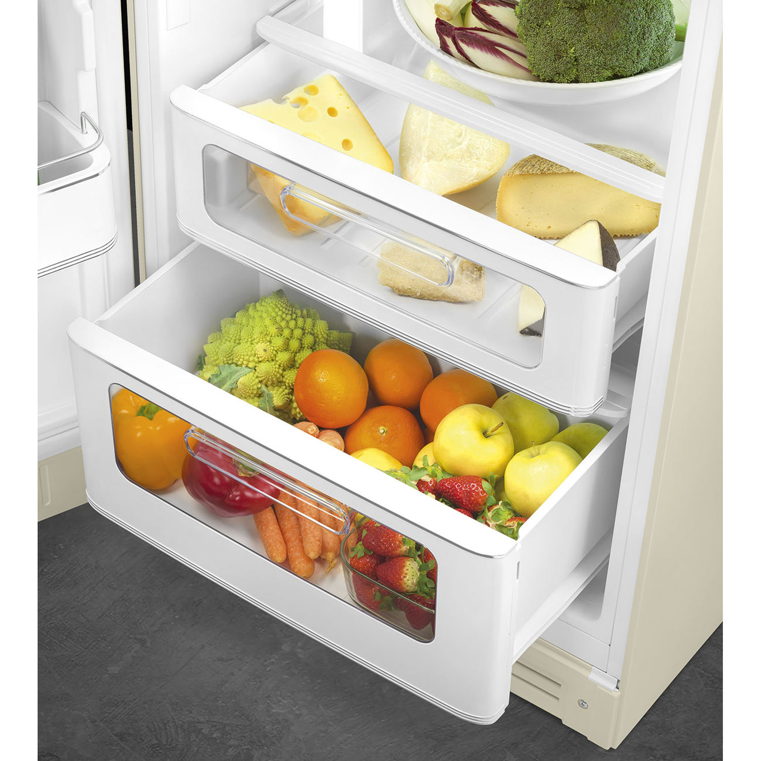 Open refrigerator with drawers filled with cheese, broccoli, fruits, and vegetables like peppers, carrots, and strawberries.