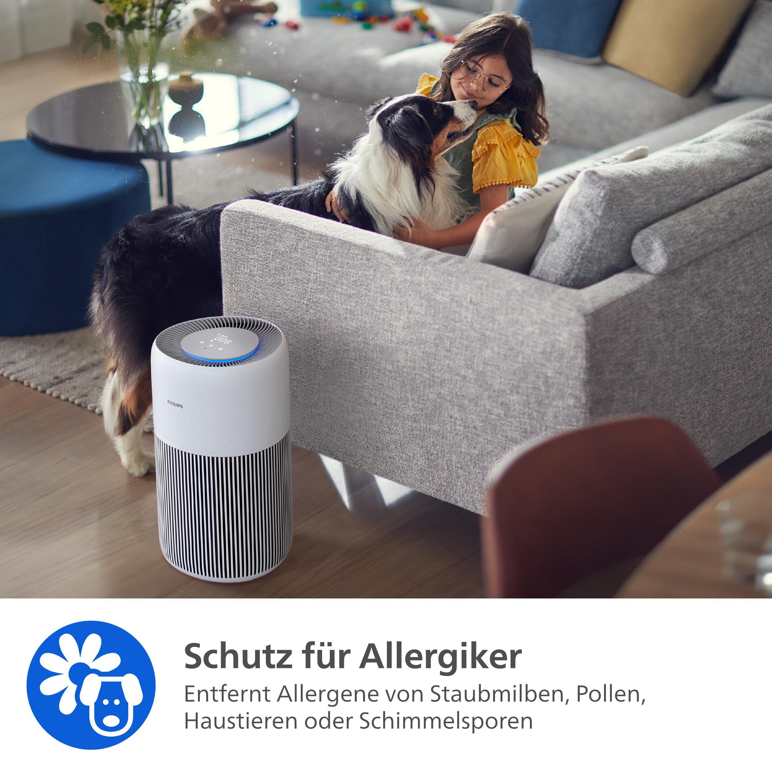 Ein Mädchen streichelt einen Hund auf einem Sofa. Ein Luftreiniger ist im Vordergrund. Text: Schutz für Allergiker.