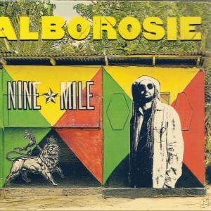 Albumcover: Alborosie, Nine Mile. Zeigt einen Mann mit Sonnenbrille, einen Löwen und bunte Tafeln.