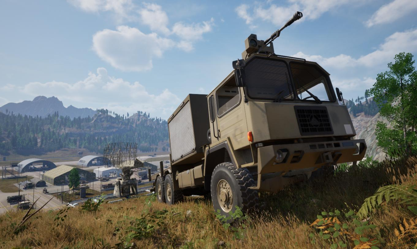 Militär-LKW auf einem Hügel. Berge und Gebäude sind im Hintergrund, unter einem bewölkten Himmel.