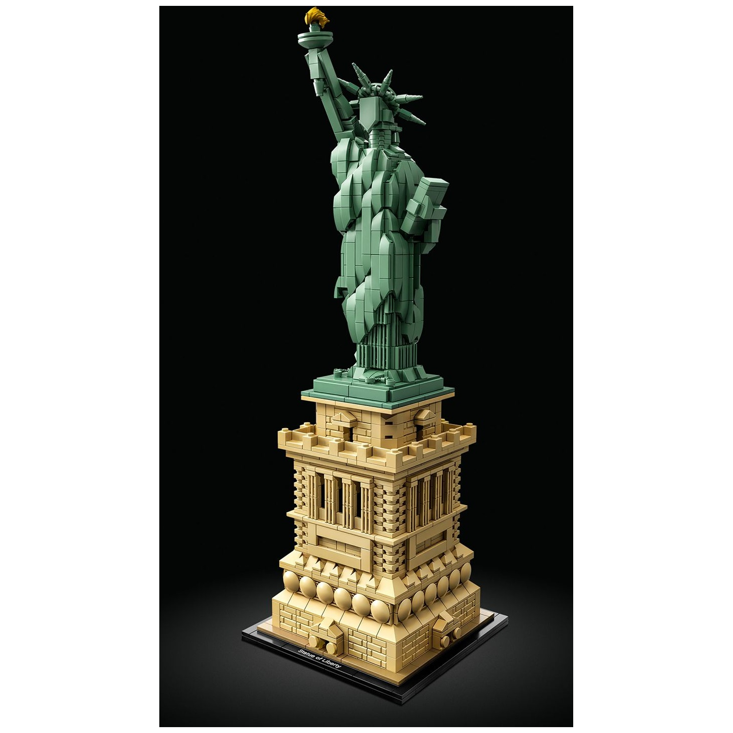 Un modèle Lego de la Statue de la Liberté, statue verte sur un piédestal beige, sur fond noir.