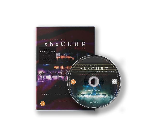 DVD-hoes en schijf voor 'The Cure', met concertbeelden. Hoes is bordeauxrood met bandnaam. Schijf toont podium.