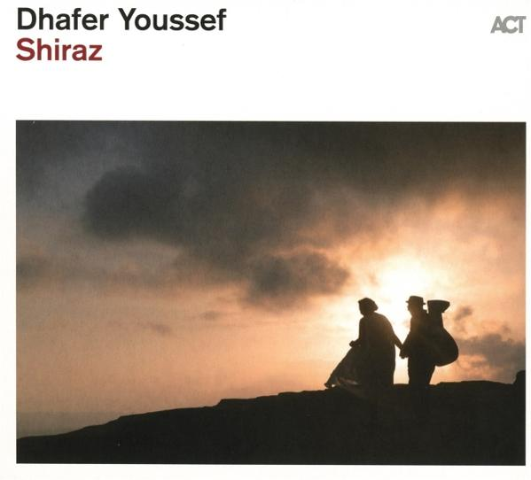 Schattenfiguren gehen bei Sonnenuntergang auf einem Bergrücken. Dunkle Wolken dominieren den Himmel. Das Cover zeigt 'Dhafer Youssef Shiraz'.